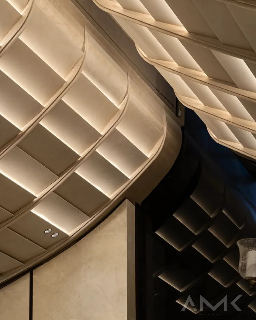 Lit plaster ceiling vaults curving overhead, with the AMK mark