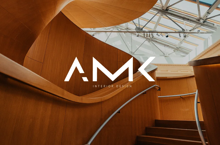The AMK mark over a timber spiral stair under a skylight
