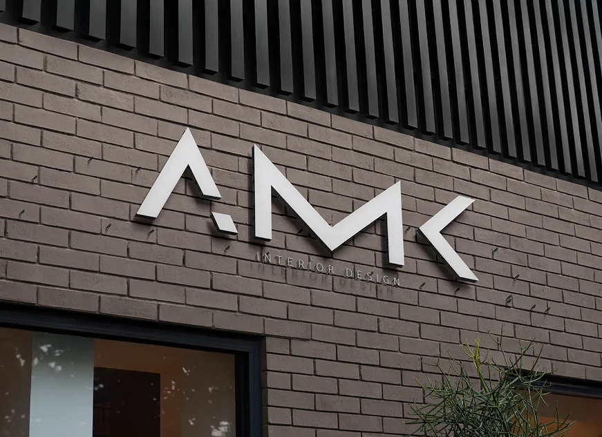 The AMK Interior Design sign mounted on a brick façade