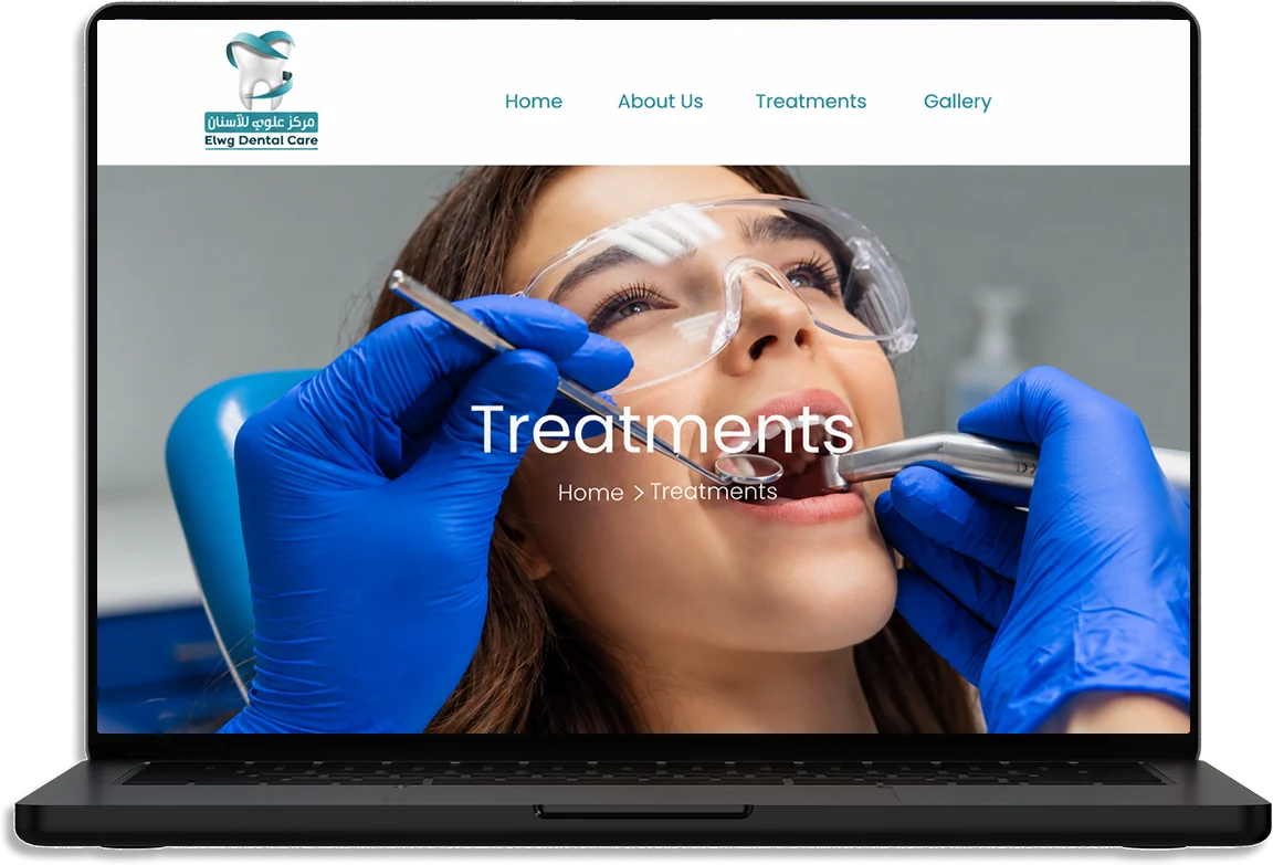 The Elwy Dental Care website on a laptop: the Treatments page over a dentist examining a patient