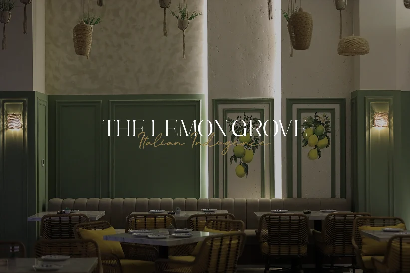 The Lemon Grove wordmark over the green panelled dining room with lemon artwork