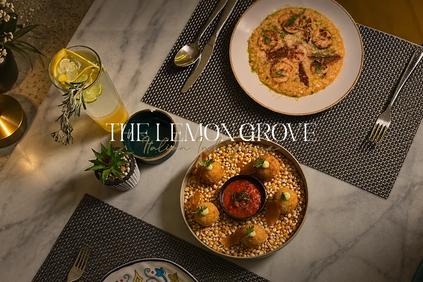 The Lemon Grove wordmark over risotto and arancini on a marble table