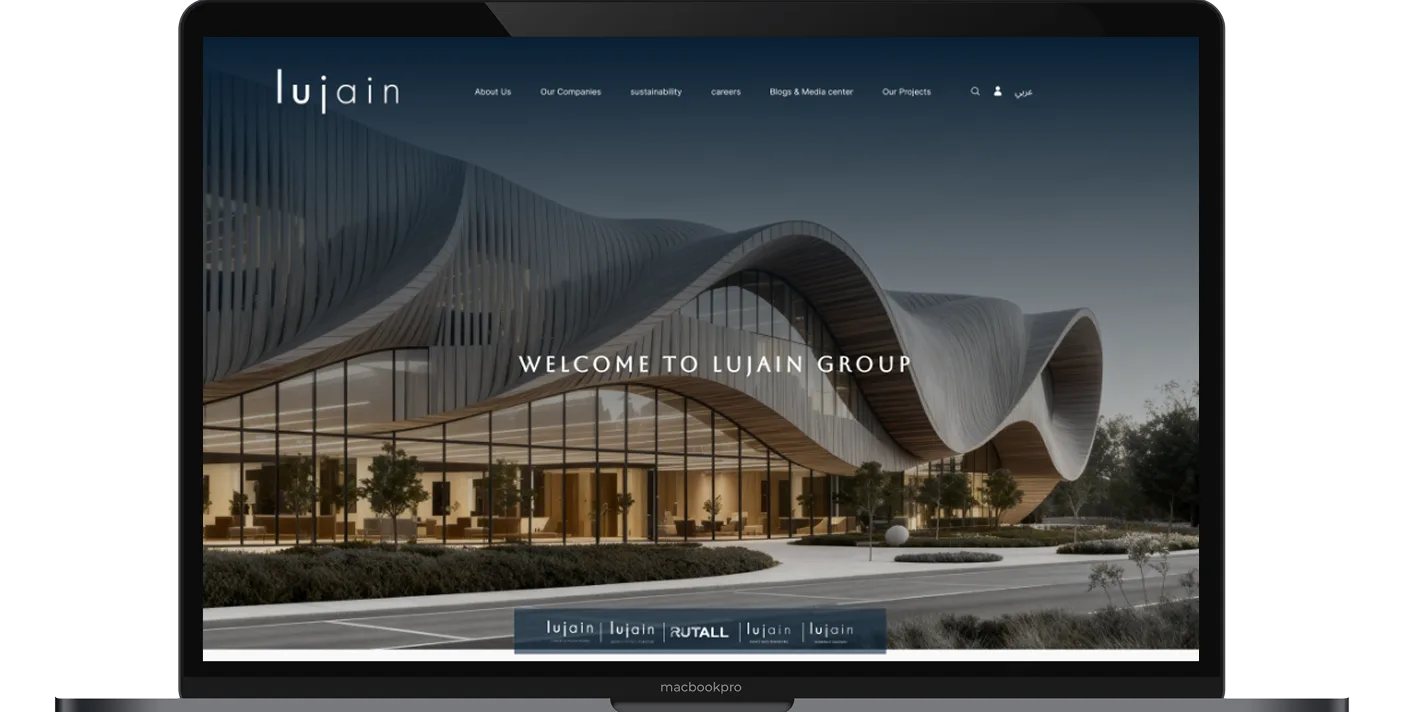 The Lujain Group website open on a laptop: Welcome to Lujain Group, over a waved timber facade